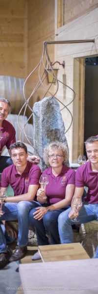 photo d'une famille en tee shirt rouge assise avec chacun un verre de ivn