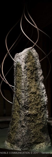 photo d'un menhir entouré d'eau et de 7 fils en cuivre