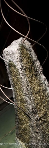 photo d'un menhir entouré d'eau et de 7 fils en cuivre