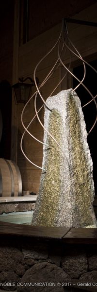 photo d'un menhir entouré d'eau et de 7 fils en cuivre