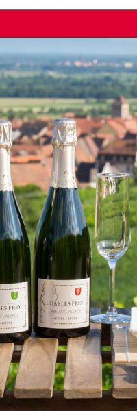 4 bouteilles de Crémant d'Alsace sur une table dans les vignes